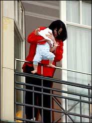 Michael Jackson dangles his baby